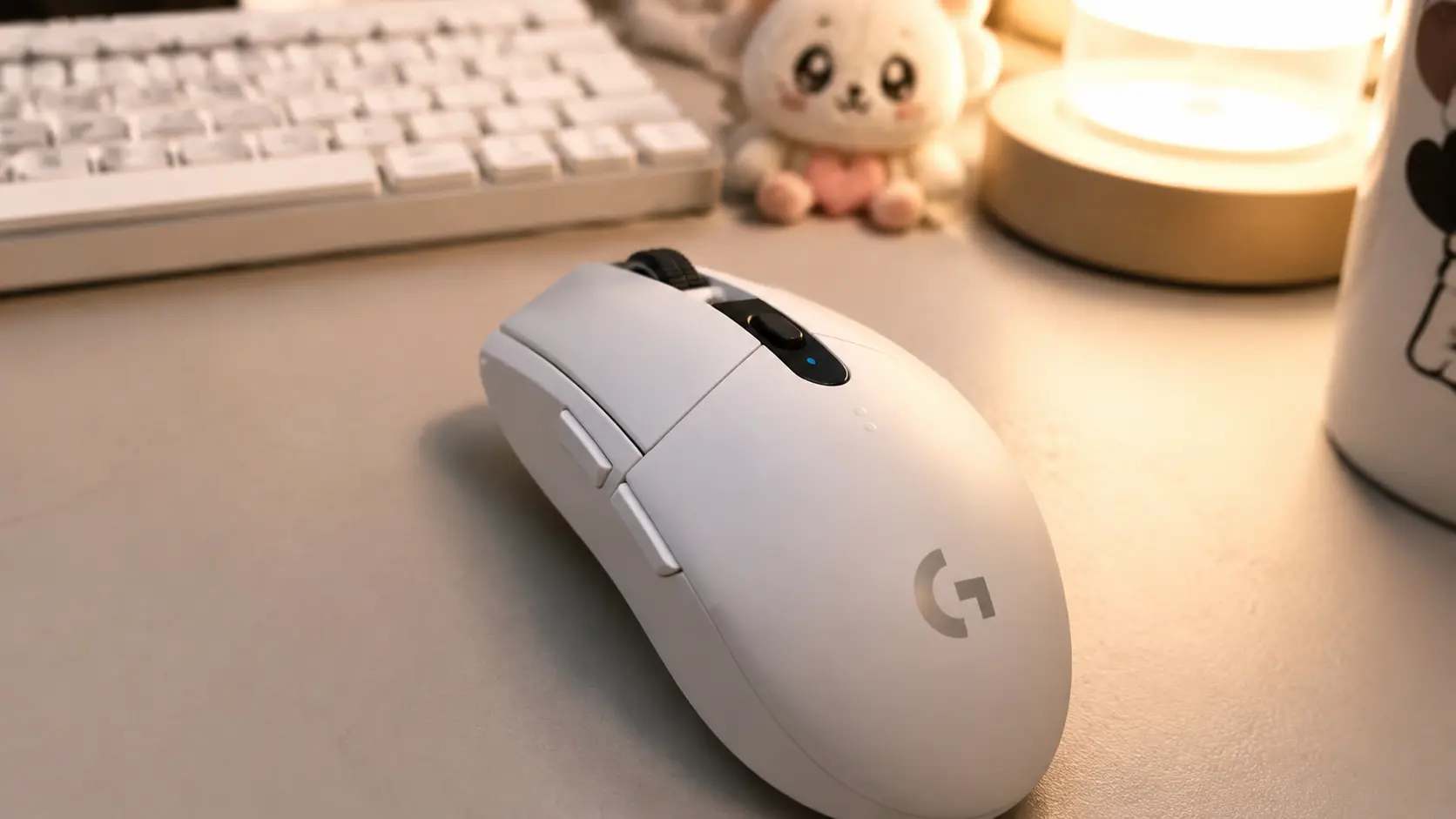 Clean white wireless gaming mouse on a cozy aesthetic desk setup
