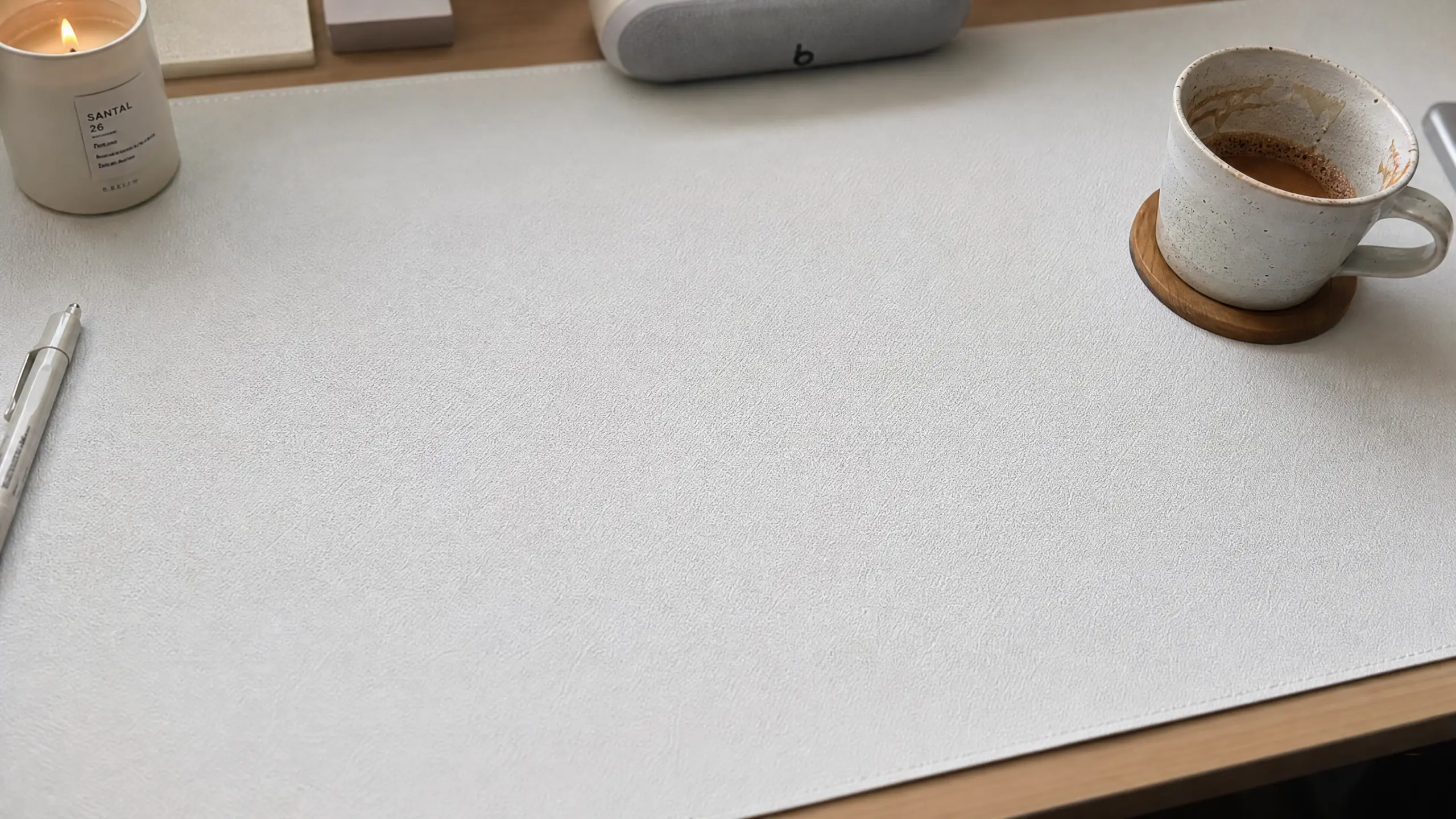 Pure white minimalist desk mat framing a clean cozy workspace