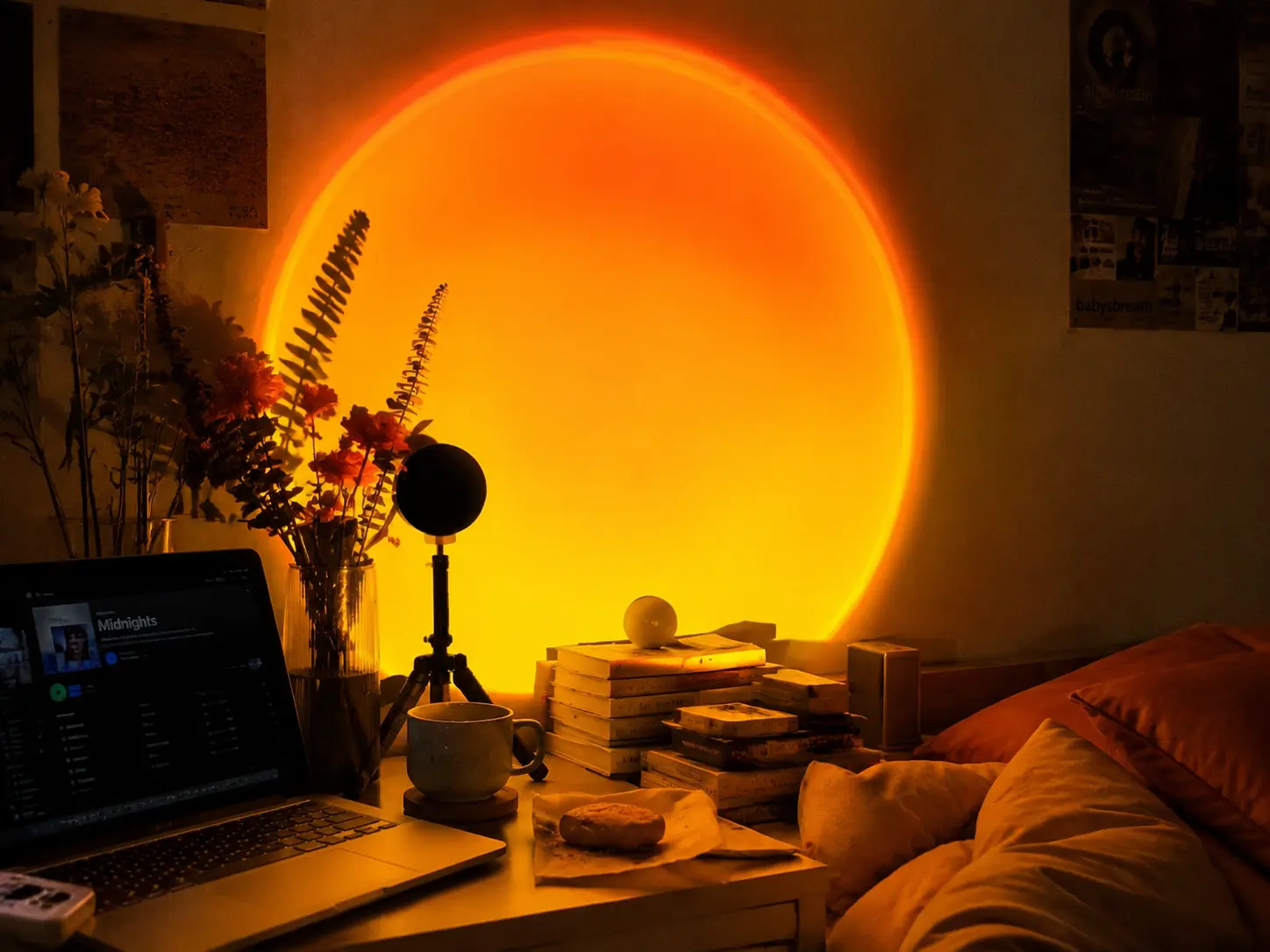 Sunset projection lamp casting warm orange light on a lofi desk setup