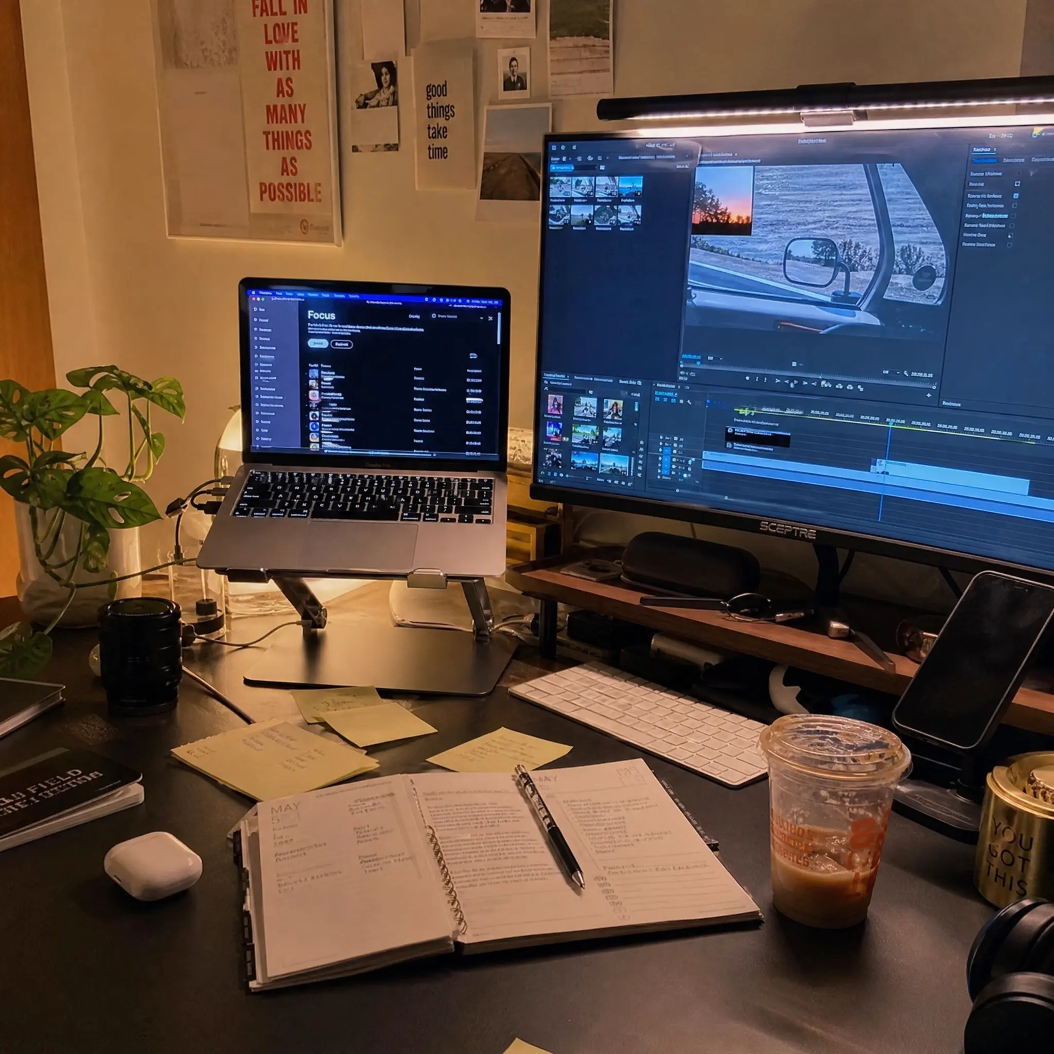 Lived-in cozy Mac creator desk setup with an aluminum laptop stand
