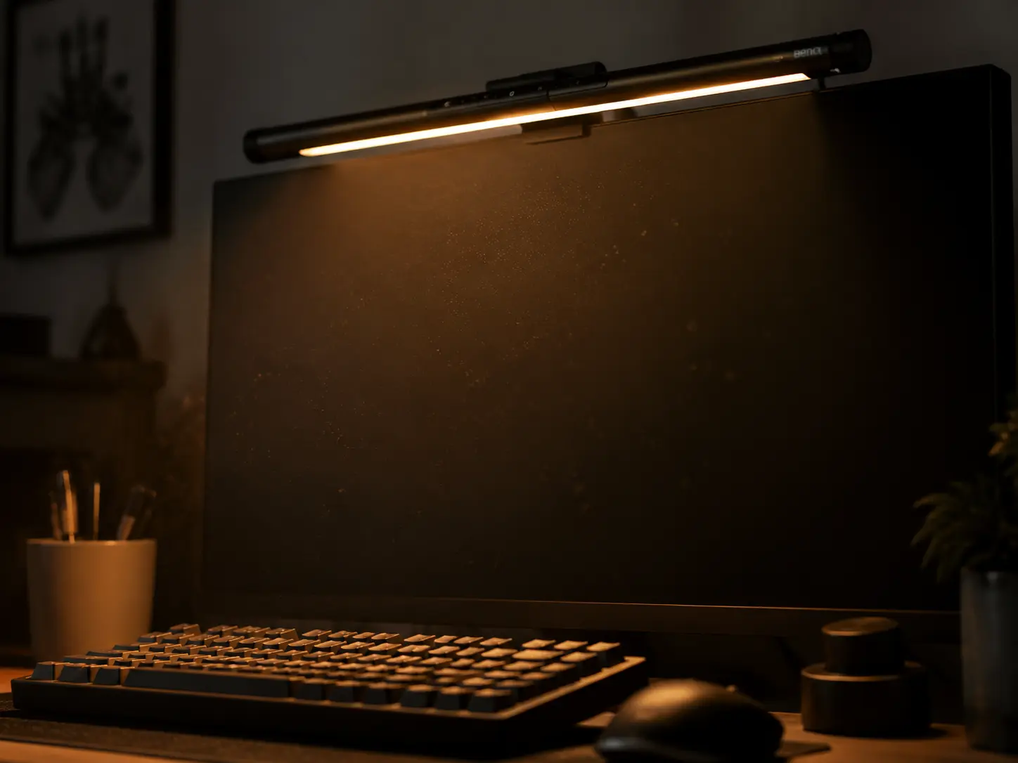 Close up of a premium monitor light bar illuminating a dark desk setup