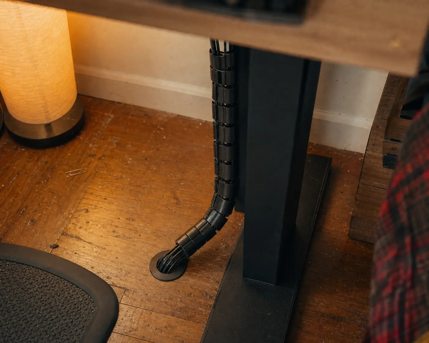 Flexible cable management sleeve routing wires neatly to the floor