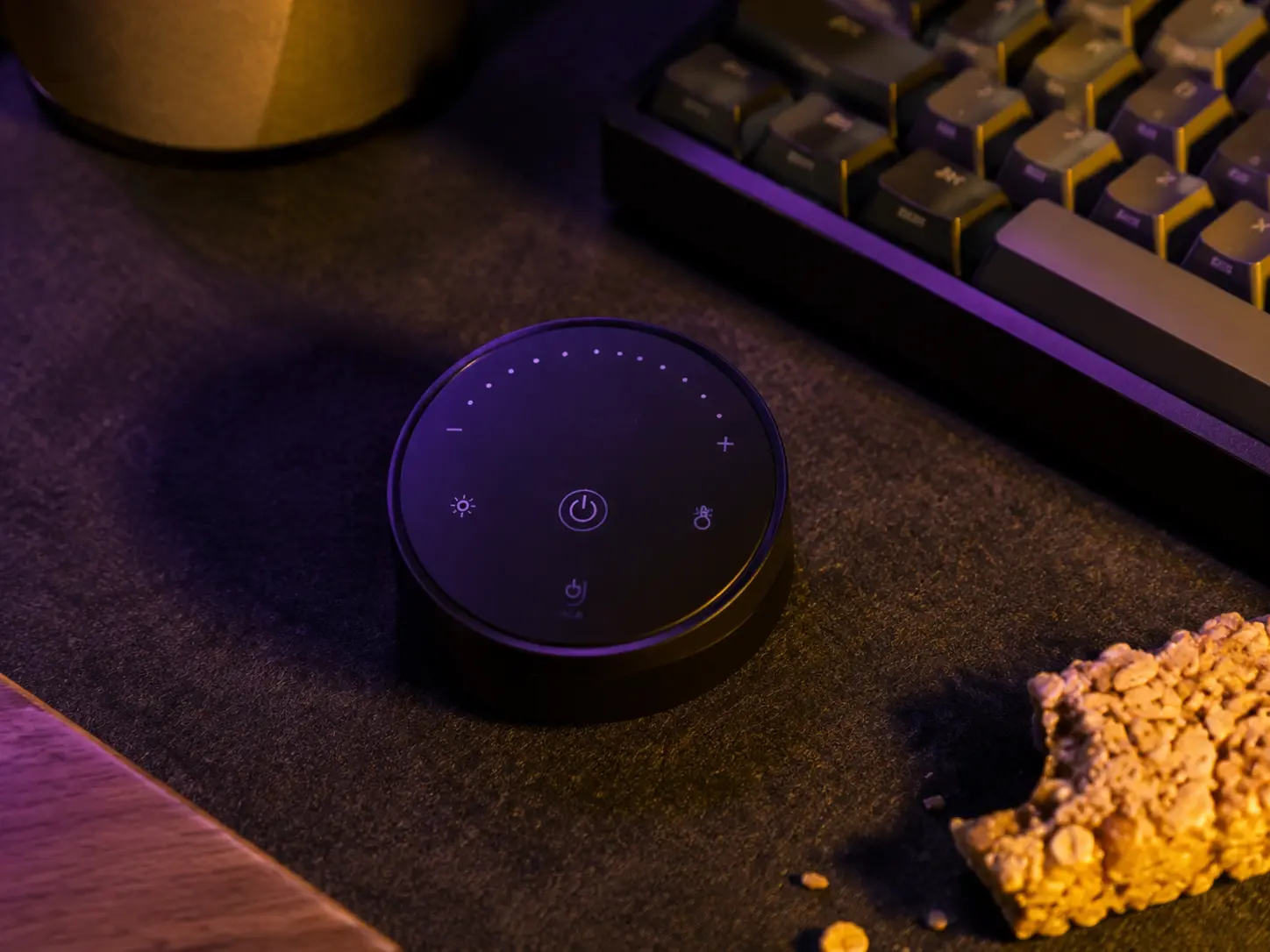 Wireless matte black dial controller for a monitor light bar on a desk mat