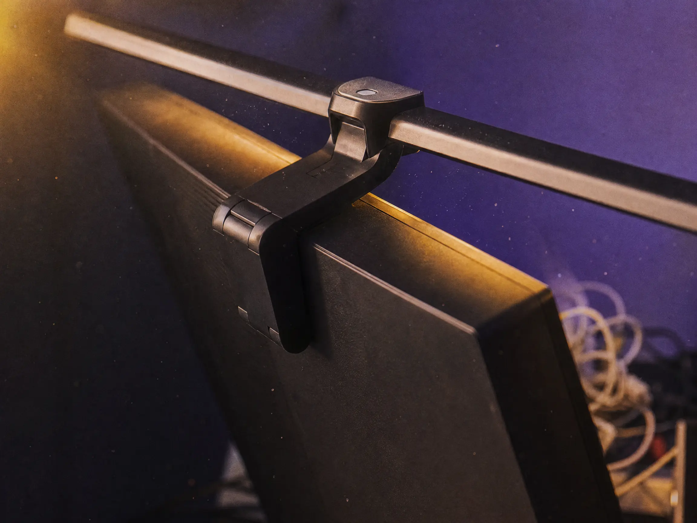 Aluminum mounting clip of a curved monitor light bar resting securely on a screen