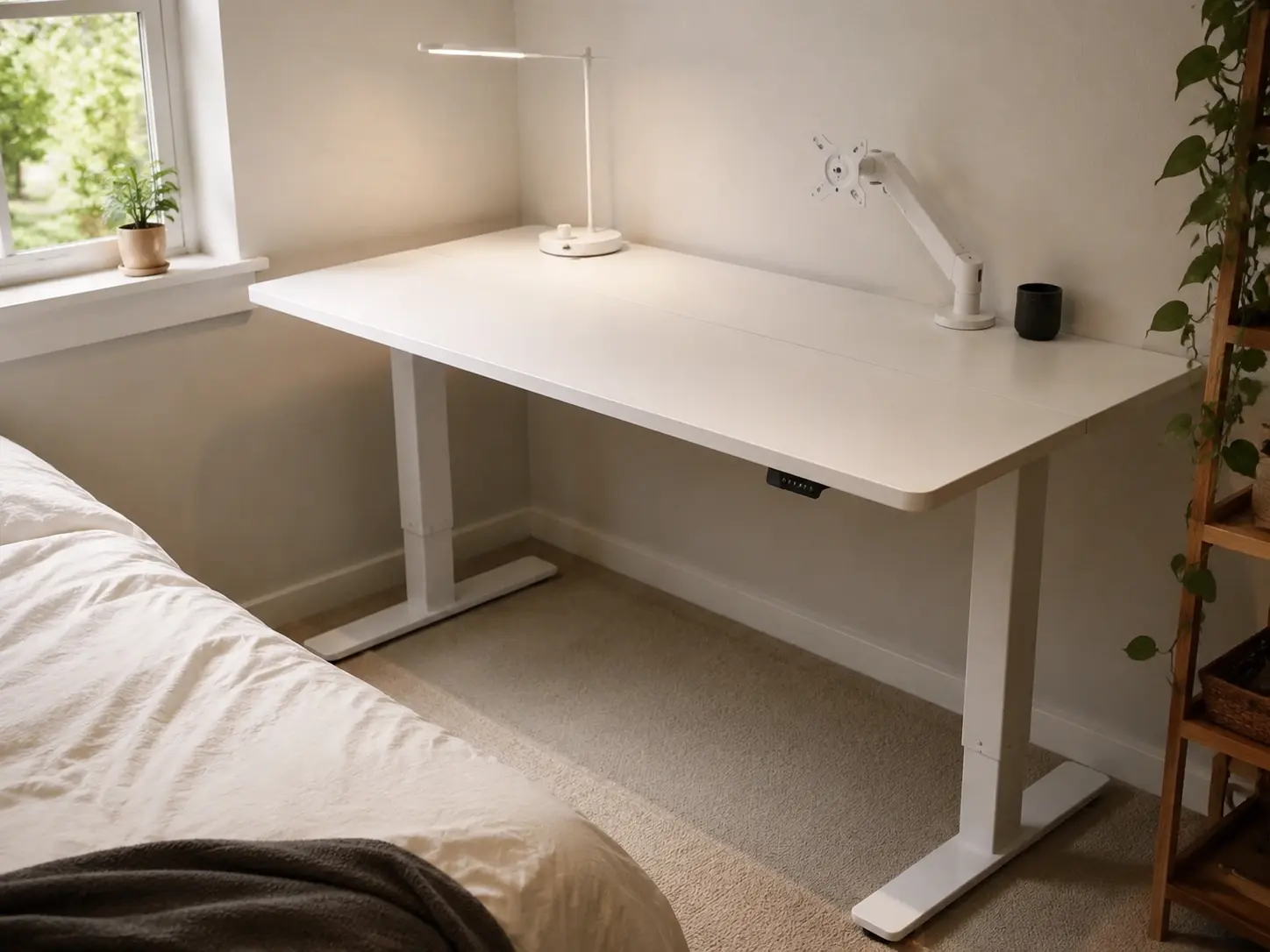 White electric standing desk in small bedroom corner