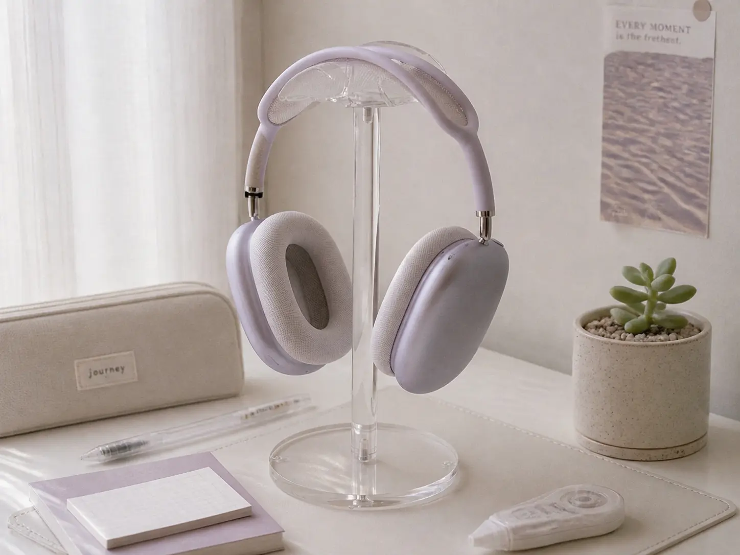 Clear acrylic headphone stand holding pastel headphones