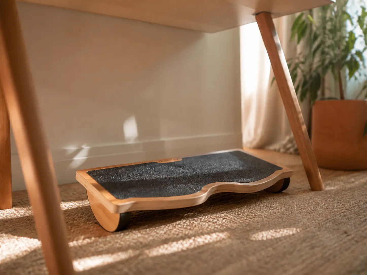 Minimalist natural wooden rocking ergonomic footrest under a desk with soft window light